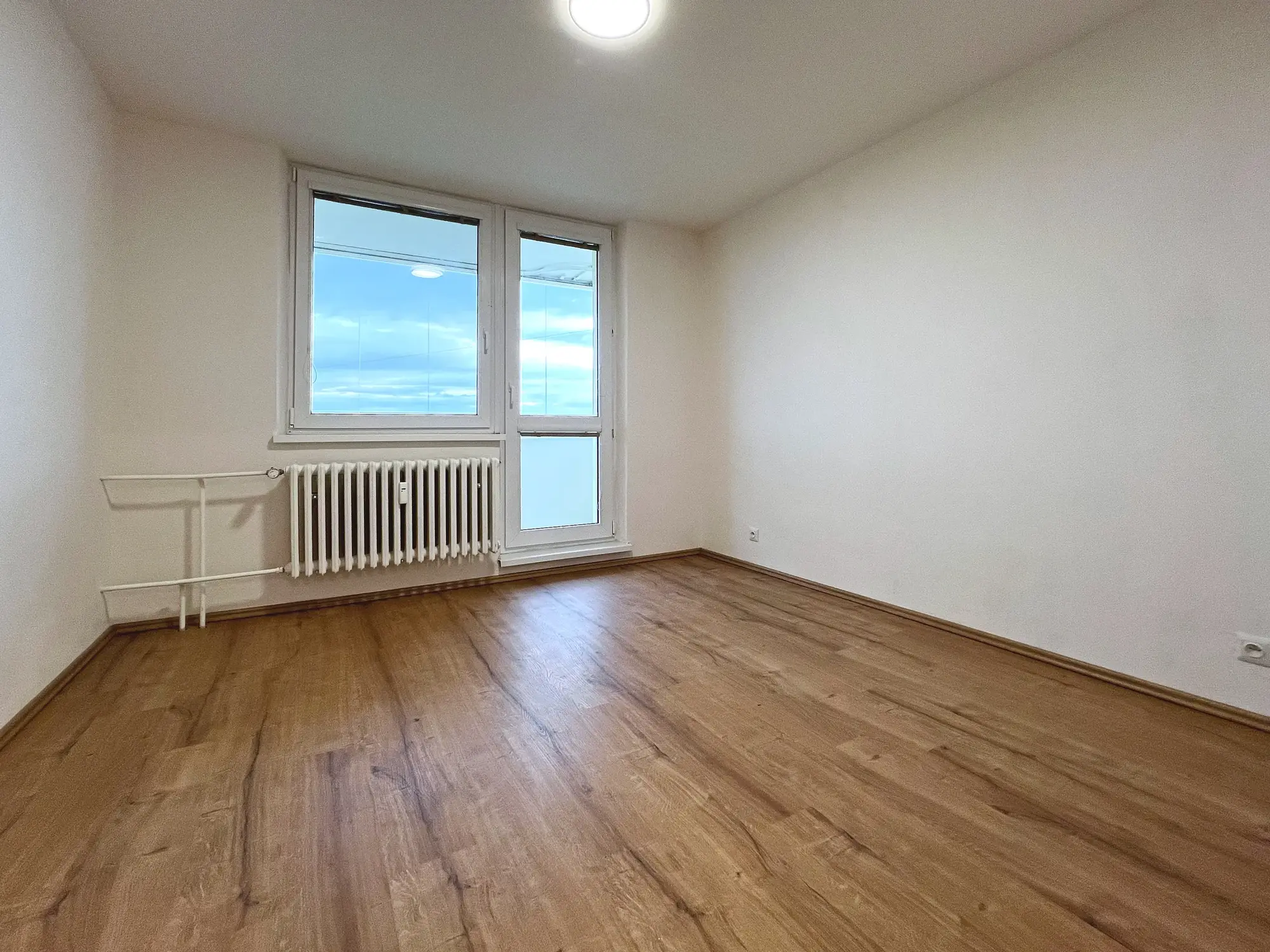 Pokoj s oknem a dveřmi na balkon